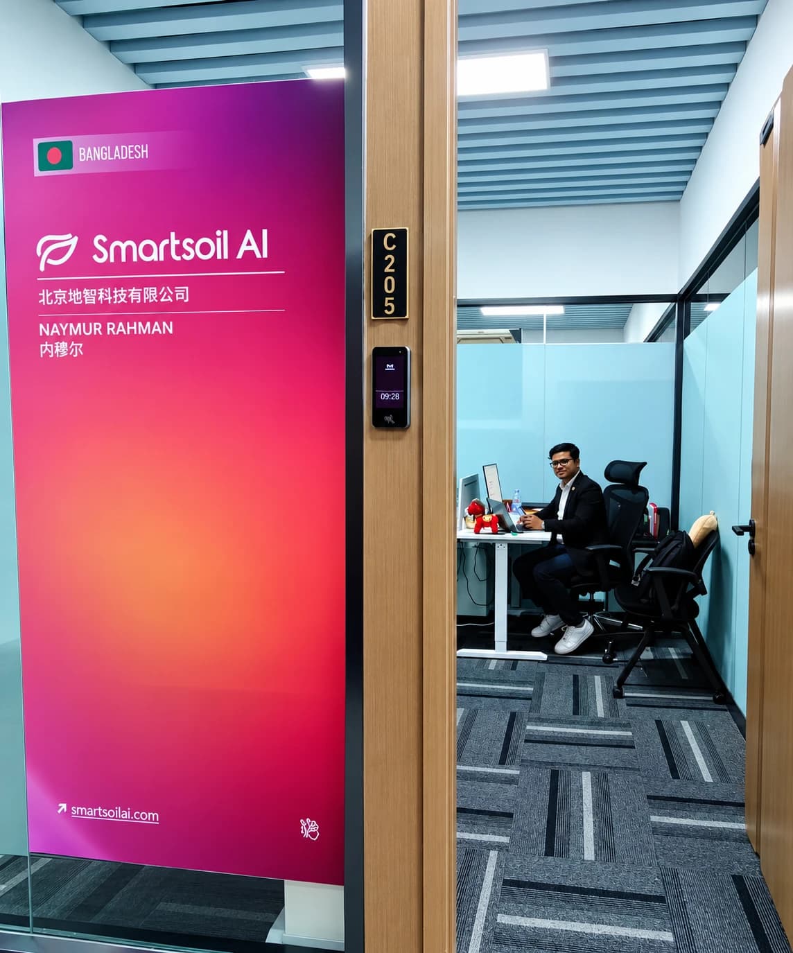 Вратата на офиса на SmartSoil AI в стая C205, Пекин, със служител на бюрото си